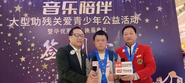 　　(图为彭道坚会长、唐氏综合征少年罗城、华悦服务队队长邓国权接受记者采访)